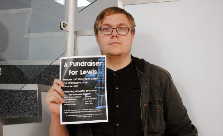 Lewis holding a fundraising poster for the gig